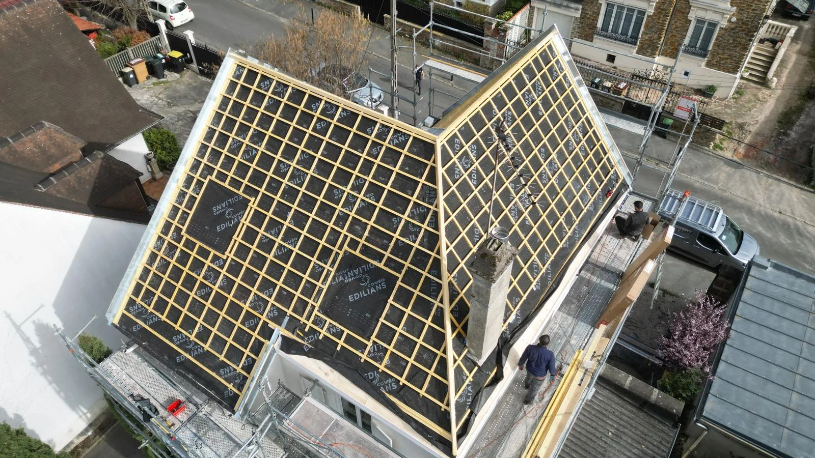 Chantier de rénovation d'une toiture traditionnelle en tuiles mécaniques en cours au Raincy